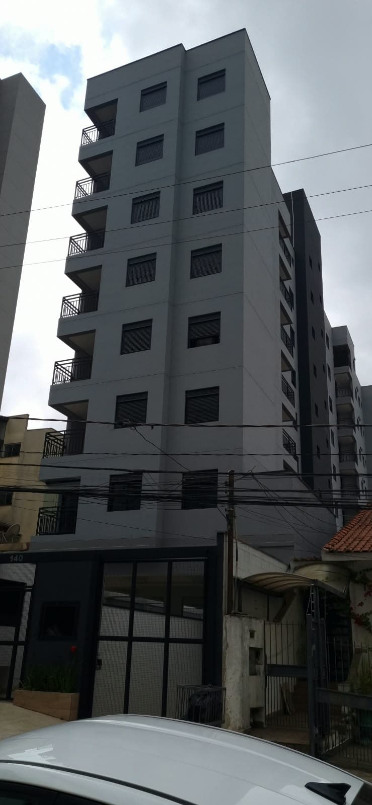 Edifício residencial de 10 pavimentos com fachada cinza e varandas